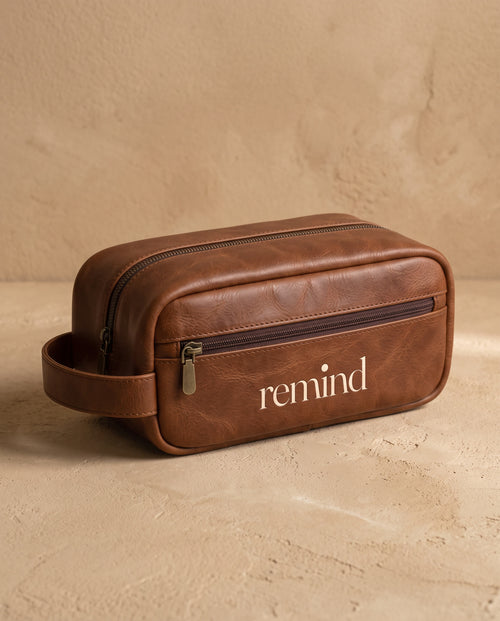 Brown toiletry bag with the REMIND wordmark
